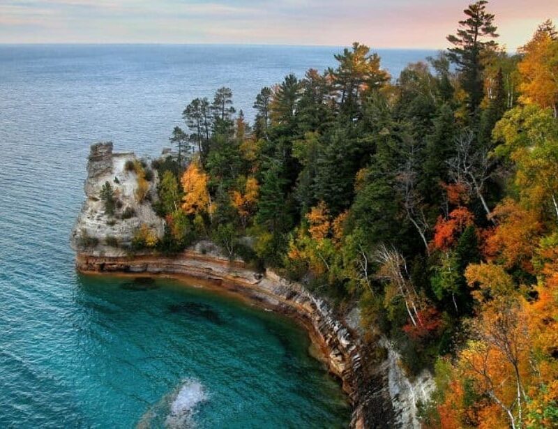 Miners Castle Point at Pictured Rocks National Lakeshore in Michigan's Upper Peninsula, particularly during autumn when the foliage displays vibrant colors.