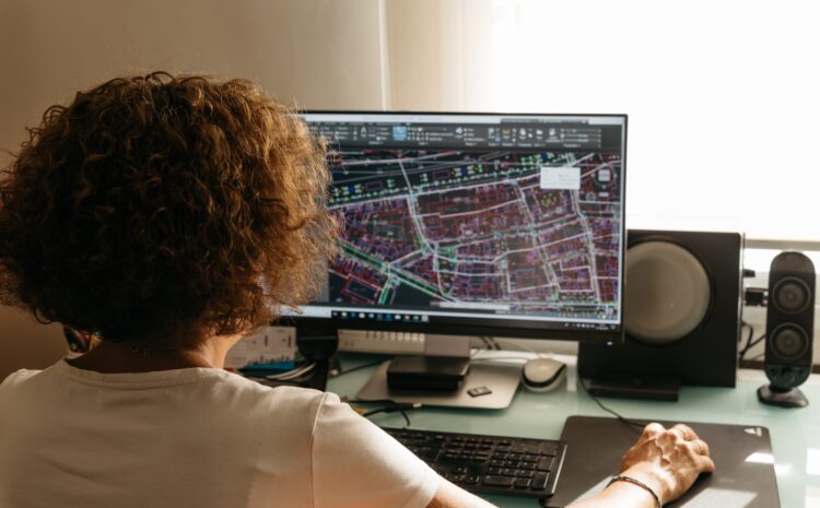 Developer holding a mouse looking at a map on a computer screen