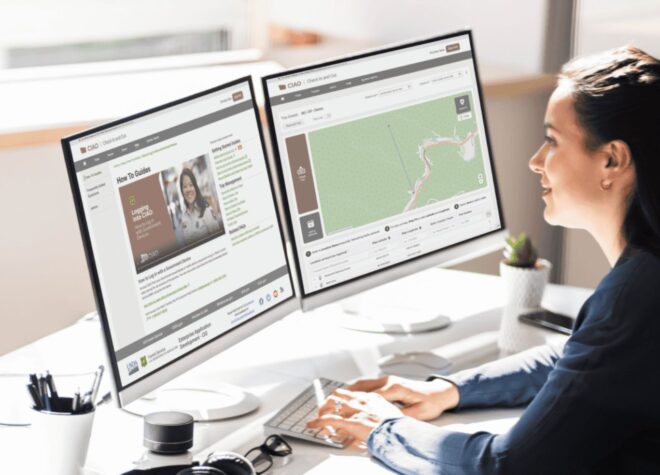 woman staring at two computer screens