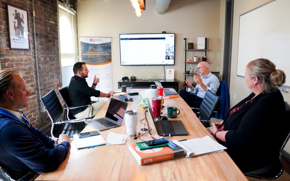 Cynerge leadership team discussing a project around the conference room table